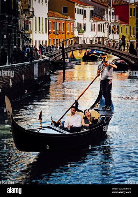 Couple Sharing A Romantic Gondola Cruise Evening In Venice Italy Stock