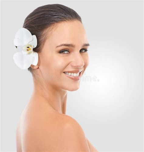 Perfecting Perfection Studio Beauty Shot Of An Attractive Brunette Woman With A Flower In Her