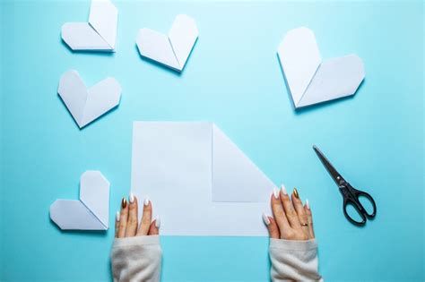 Muchos Corazones De Origami Blanco Sobre Fondo Azul Con Hoja De Papel Y