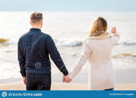 Young Couple Holding Hands At Sunset On Beach Romantic Young Couple