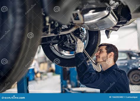 Auto Car Repair Service Center Mechanic Examining Car Suspension Stock