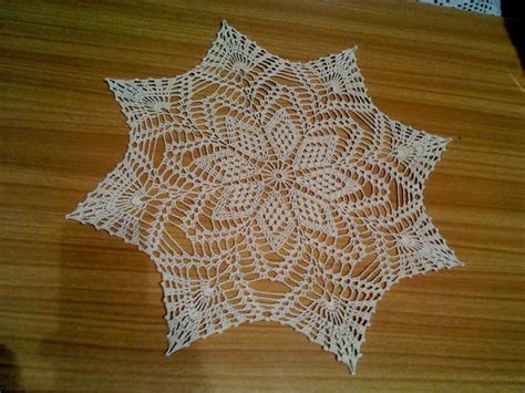 A White Doily Sitting On Top Of A Wooden Table