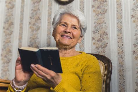 Cute Caucasian Grandmother Holding The Bible And Smiling Satisfied