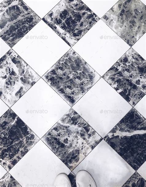 Black And White Checkered Marble Floor With Two Visible Human Feet