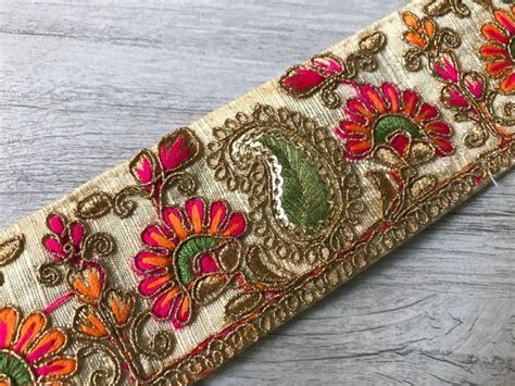 A Close Up Of An Embroidered Ribbon On A Wooden Surface