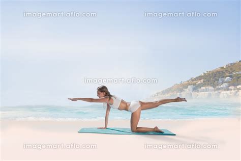 Composite image of gorgeous fit blonde in pilates pose on the beachの写真