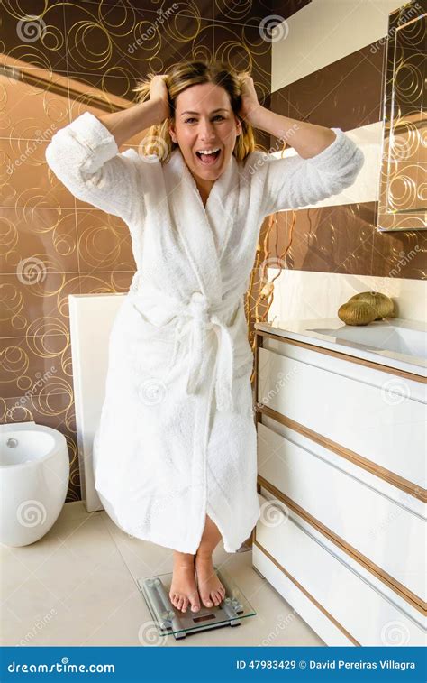 Woman Standing On Bathroom Scale Crazy With Her Weight Stock Image