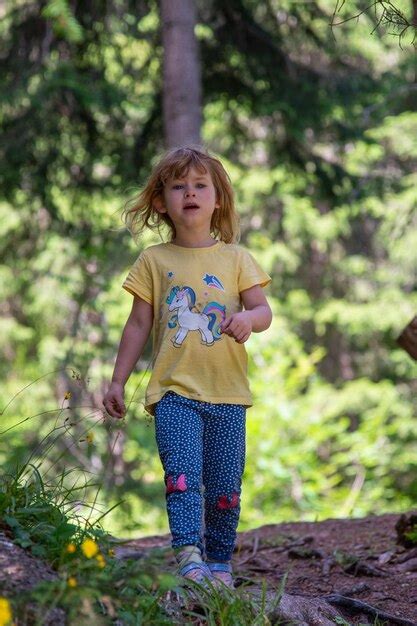 Premium Photo Portrait Of Young Girl Standing Against Trees