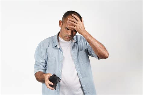 Upset Man Holding And Looking Inside His Empty Wallet No Money