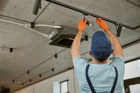 Premium Photo Male Electrician Fixing Ceiling Lamp In Building