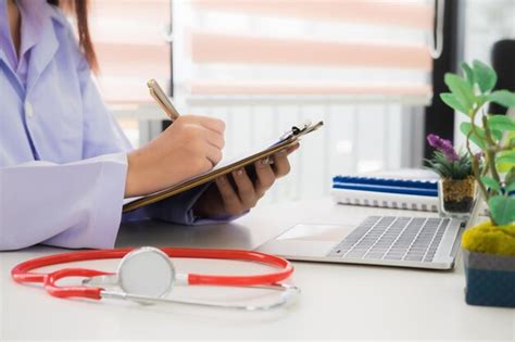 Premium Photo Midsection Of Female Doctor Writing Prescription In Office