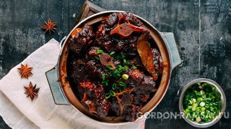a pot filled with meat and vegetables next to some spices
