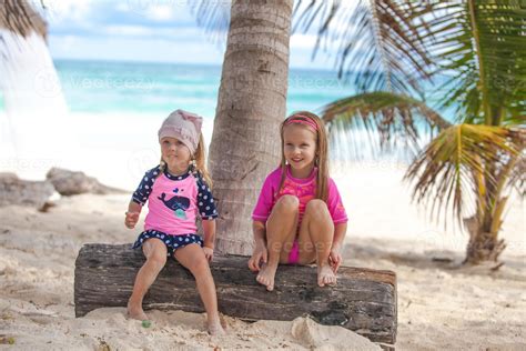 Two Little Sisters In Nice Swimsuits Have Fun At Tropical Tulum Beach