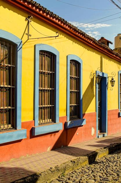 Un Edificio Colorido Con Una Pared Amarilla Y Roja Y Ventanas Azules