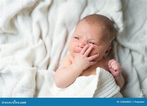 Newborn Baby Lying On Bed Covered By A White Blanket Top View Stock