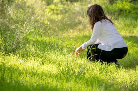 Premium Photo Woman Crouching On Grassy Field