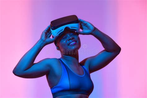 African American Woman Streamer Playing Video Game Using Virtual Reality Glasses At Gaming Room