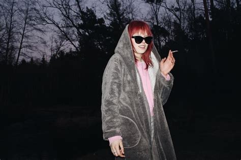 Premium Photo Portrait Of Woman Wearing Sunglasses Smoking In Forest