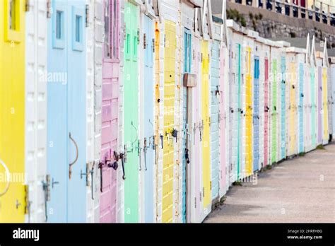 Multi Coloured Wooden Beach Huts In Pastel Colours On The Seafront At