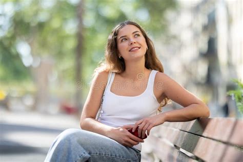 Long Haired Brunette Girl With Phone Sit And Rest On Bench In City Street Stock Photo Image Of