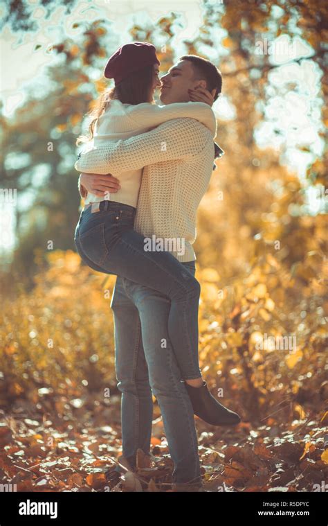 Sweet couple is in the park, hugging and looking very happy, enjoying ...