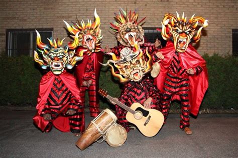 Three People In Red And Black Costumes With Masks On Their Faces One