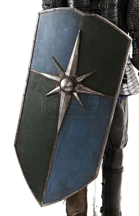 A Man Dressed In Armor And Holding A Shield With A Pointed Star On It S