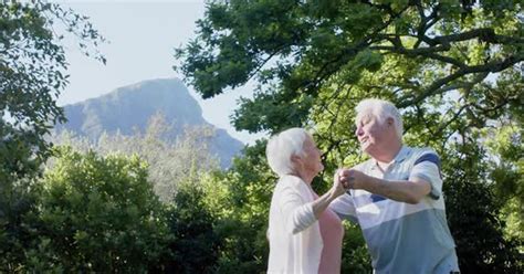 Happy Senior Caucasian Couple Dancing In Sunny Garden Slow Motion Copy Space People Stock