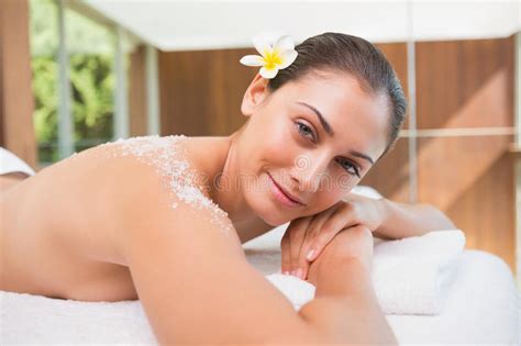 Beautiful Smiling Brunette Lying On Massage Table With Salt Scrub On