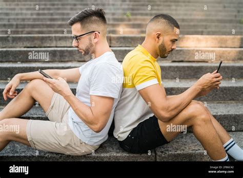 Gay Couple Ignoring Each Other While Using Their Phones Stock Photo Alamy