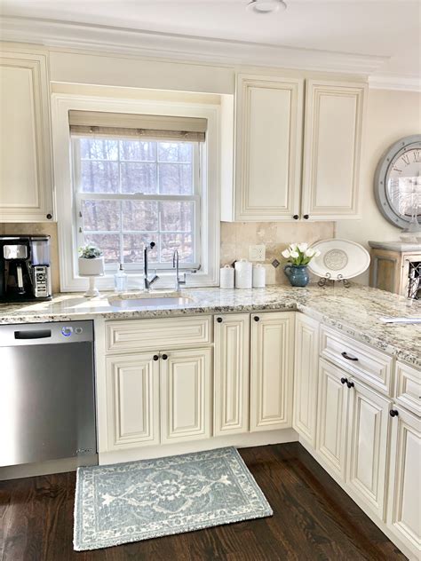 Beige kitchen cabinets and granite countertop. Kitchen styled with blue ...