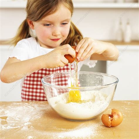 Girl Cracking An Egg Into A Bowl Of Flour Stock Image C