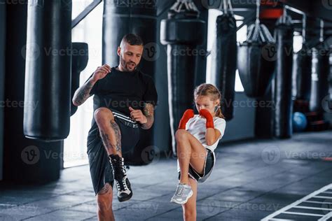 coups de poing de base jeune entraîneur de boxe tatoué enseigne une