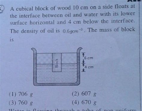 A Cubical Block Of Wood 10 Cm On A Side Floats The Interface Between