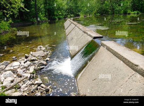 Spillway over a small dam regulates the amount of water in an artificial man made lake Stock ...