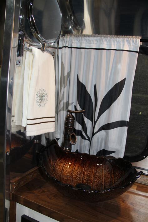 A Bathroom Sink Sitting On Top Of A Wooden Counter Next To A Mirror And
