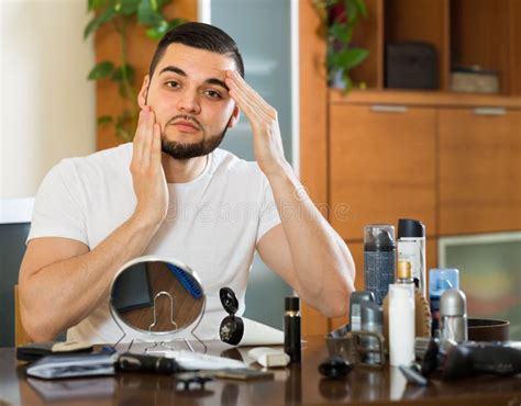 Homem Que Aplica O Creme Facial Em Casa Foto De Stock Imagem De