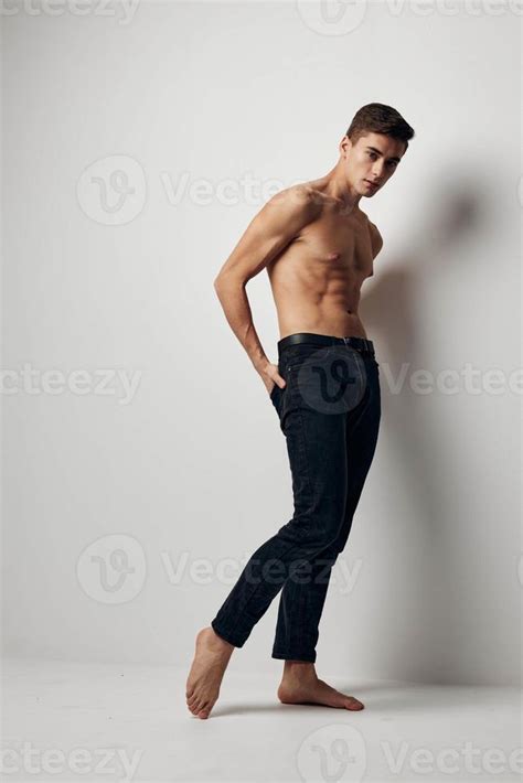 Sexy Man With A Naked Torso And In Trousers On A Light Background