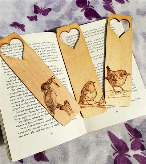 Three Wooden Bookmarks With Pictures Of Birds And Hearts On Them