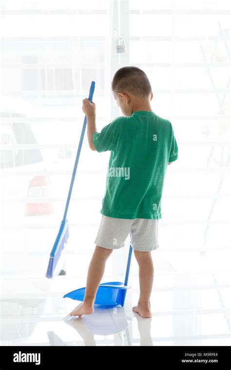 Young Child Doing House Chores At Home Asian Boy Sweeping Floor Stock