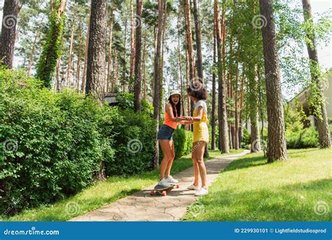 Excited Interracial Lesbian Couple Riding Skateboard Stock Image