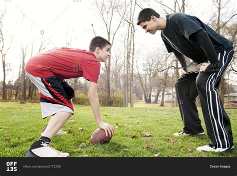 Two boys playing football in the backyard stock photo - OFFSET