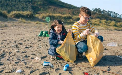 Voluntarios De Los Ni Os Que Limpian La Playa Imagen De Archivo