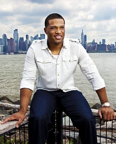 A Man In White Shirt And Blue Pants Sitting On Railing Next To Body Of