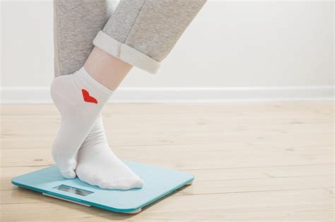Premium Photo Female Legs On Electronic Scales On A Wooden Floor