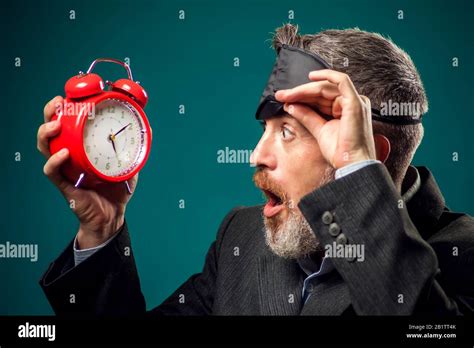 Bearded Businessman In Suit Witn Sleep Mask On Head Holding Red Alarm