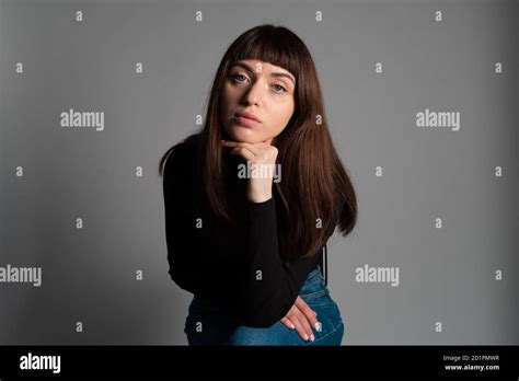 Studio Portrait Of A Pretty Brunette Woman Wearing Folded Black Polo