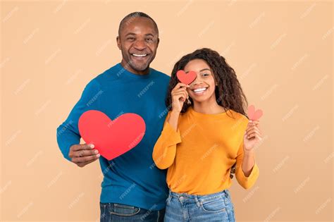 Premium Photo Love Is In The Air Romantic Black Couple With Red Paper Hearts In Hands Posing