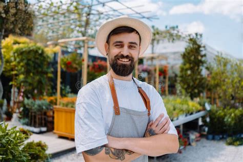 Portrait Of Male Gardener In Garden Centre Shop Assistant Looking At