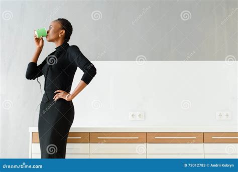 Candid Image Of A Businesswoman Drinking Coffee While Working At Light